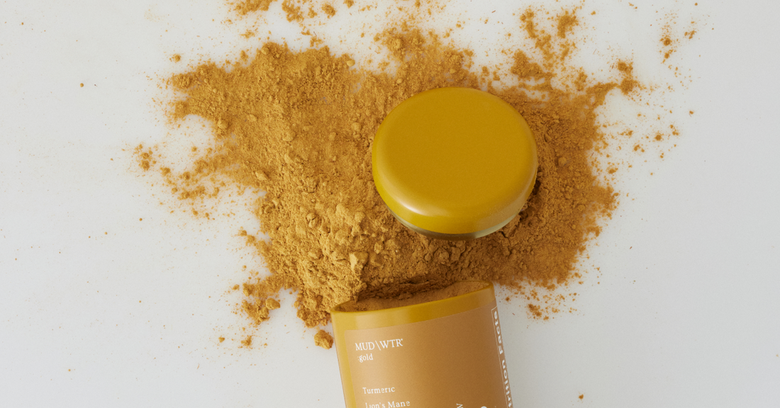 A tin of turmeric powder spilled on a counter