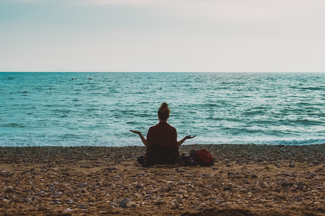 woman breathing on a beach in front of the ocean