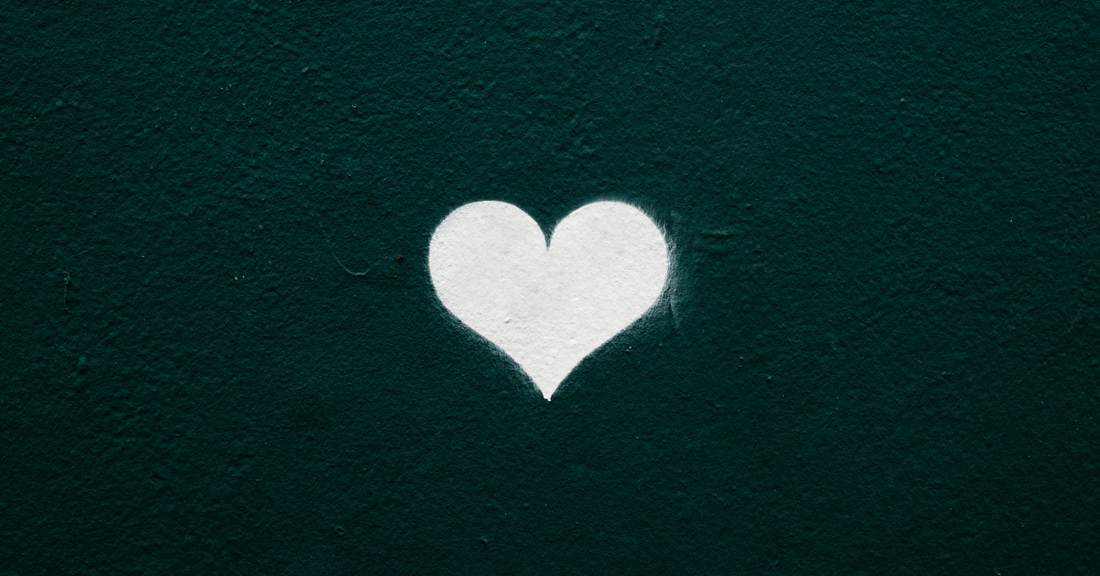 A white painted heart on a green wall