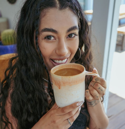 
  Woman about to drink a cup of mud water
