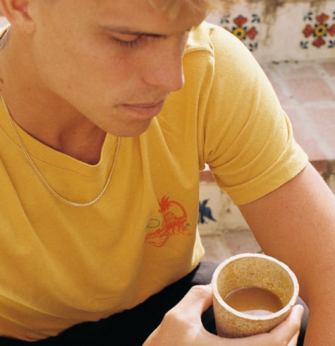 
  Man calmly holding a cup of mud water
