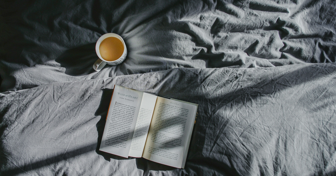 
  a book and cup of tea on a bed
