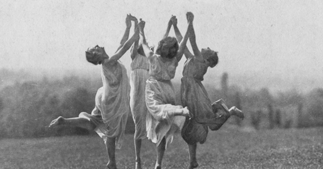 
  Four women dancing in a circle
