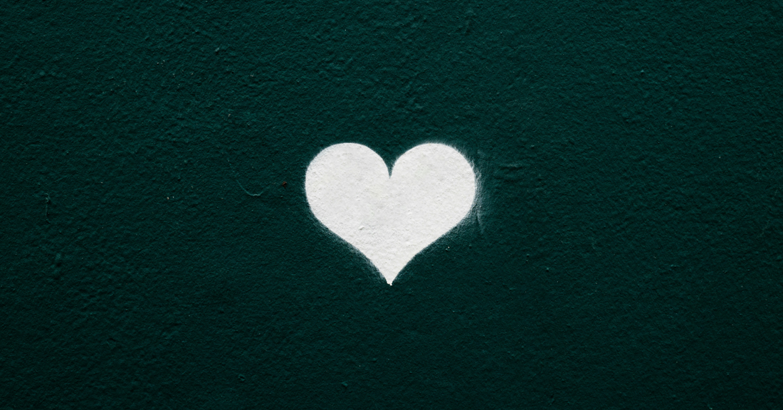 
  A white painted heart on a green wall

