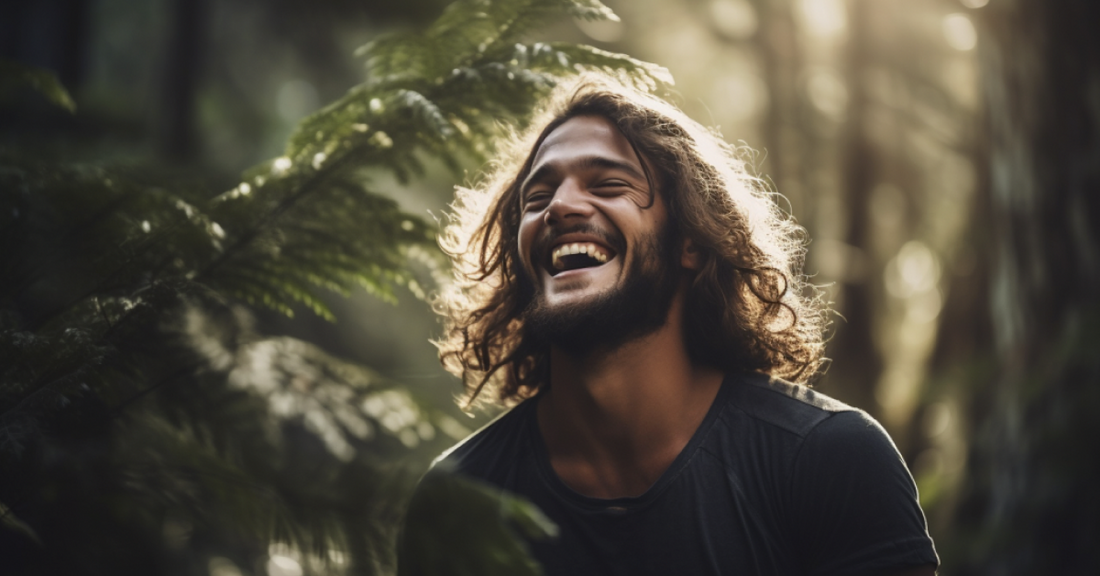 
  A man with long hair laughing in the forest
