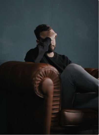 Man with headache in leather chair.